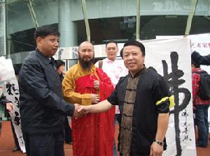 张克思(右一)身后就是他书写的“佛”字 张克思(右一)身后就是他书写的“佛”字